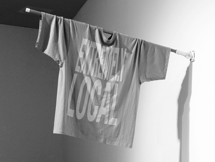 A large t-shirt on a pole with text that reads extremely local.