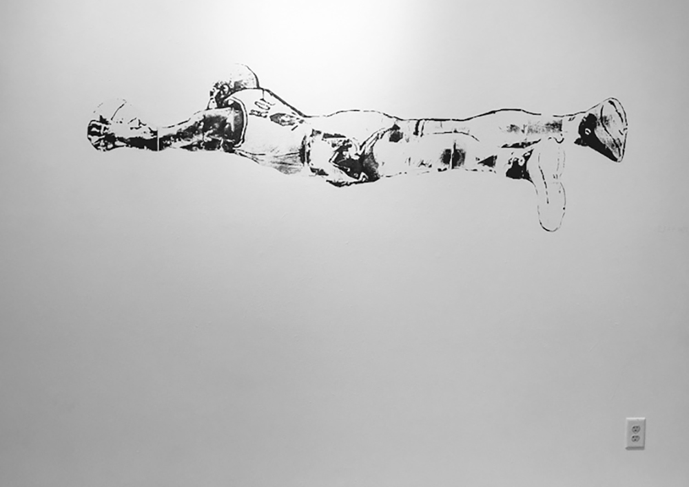 An image of dennis rodman splayed out on a floor, printed on a white wall.